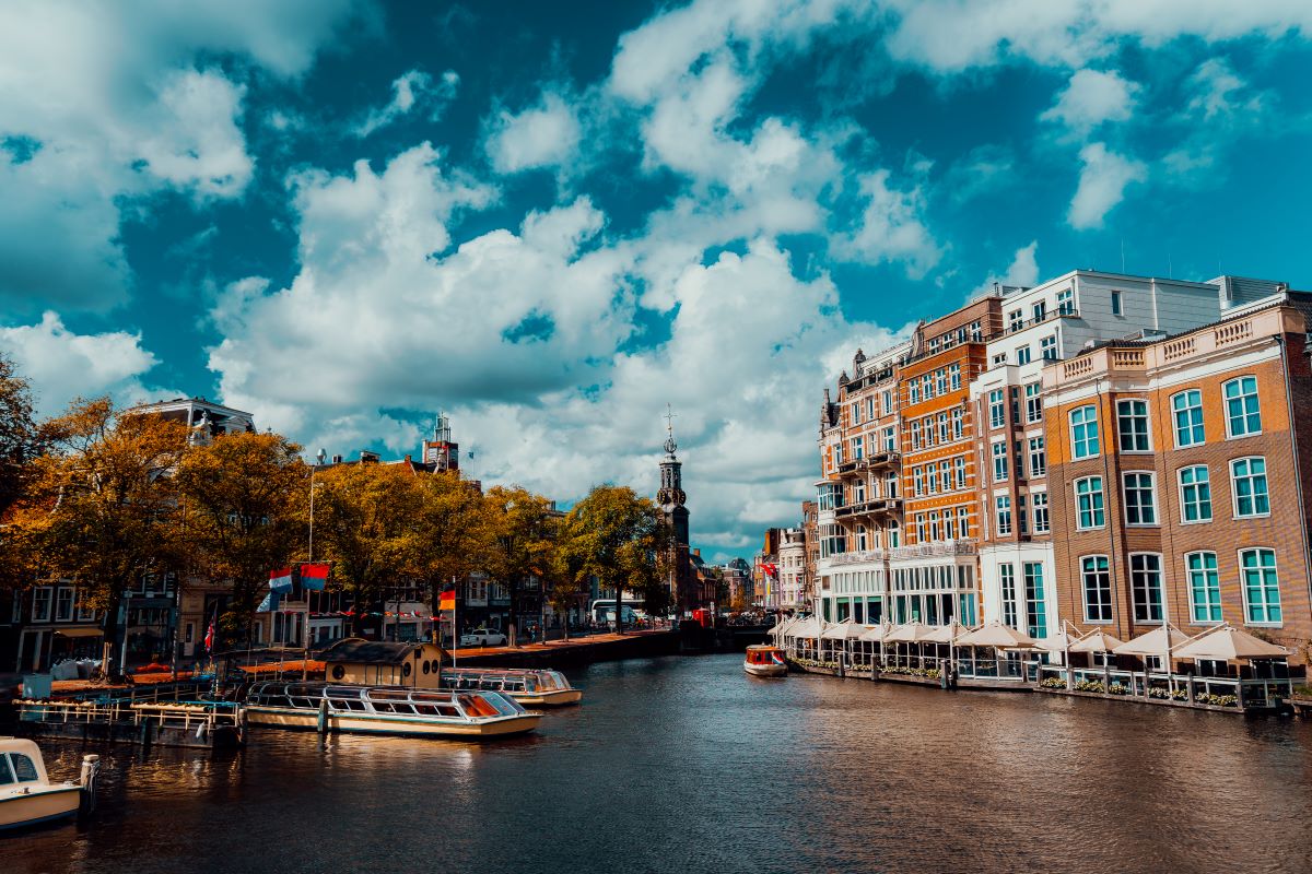 city view of amsterdam with cruise boats and typical